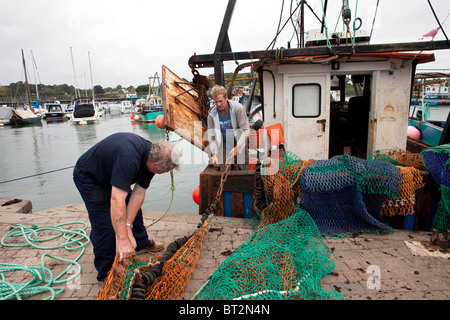 Journée de pêche côtière locale Andy Mitchell pêcheur trier ses filets sur son bateau dans le Hampshire Ville de Lymington. DAVID MANSELL Banque D'Images