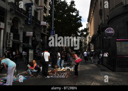 Vue urbaine d'acheteurs et vendeurs à un marché artisanal disposés sur feuilles au milieu de l'allée, Rue du Pérou, Buenos Aires Banque D'Images