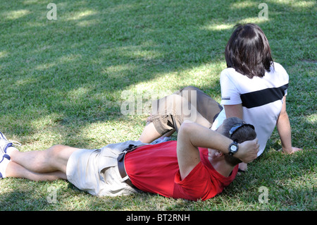 Young couple sitting on grass Banque D'Images