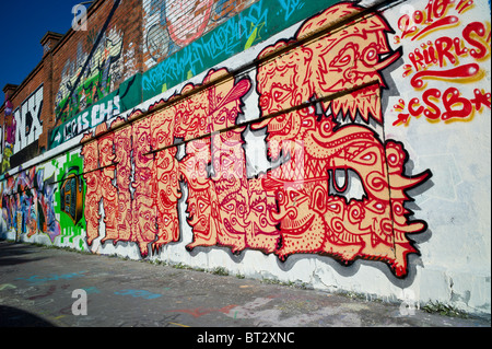 Mur recouvert de graffitis montrant asiatique style comme pièce faite de visages, Munich, Allemagne Banque D'Images