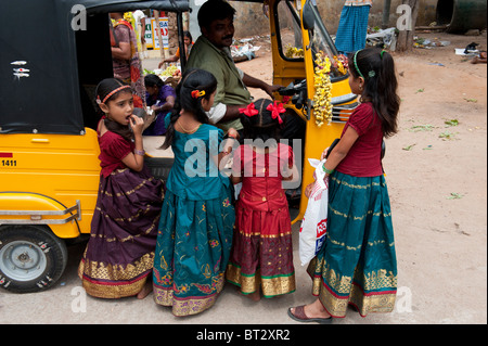 Les enfants indiens de monter dans un rickshaw à Puttaparthi, Andhra Pradesh, Inde Banque D'Images