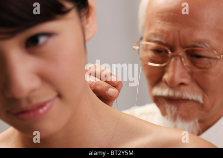 Médecin de mettre les aiguilles d'acupuncture sur le cou de la femme , close-up Banque D'Images