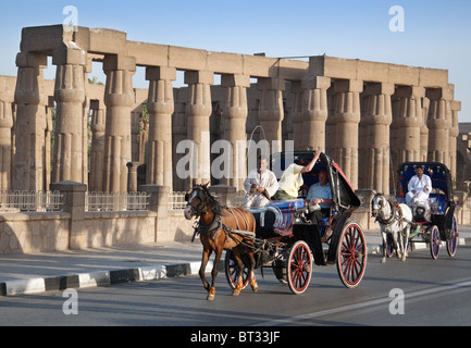 Temple de Louxor; touristes en chevaux et en calèches (Hantoors) qui passent devant le temple de Louxor, en Haute-Egypte Banque D'Images