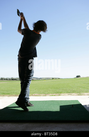 Teenage boy at driving range Banque D'Images