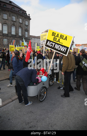 Petite fille en vélo transporteur démontrer devant le Parlement à Copenhague pendant la Conférence des Nations Unies sur le changement climatique. Les mars. Banque D'Images