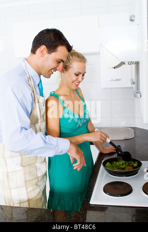 Jeune couple heureux à la cuisson des aliments dans la cuisine Banque D'Images