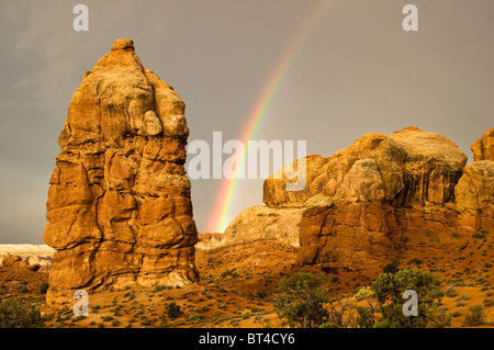 Un arc-en-ciel apparaît après un orage passe par des formations de grès dans le Parc National des Arches près de Moab dans l'Utah. Banque D'Images