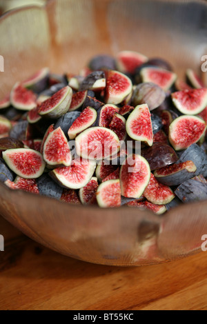 (Ficus carica) figues mûres fraîchement cueillies dans un bol en verre, coupées en quartiers / coupées en deux Banque D'Images