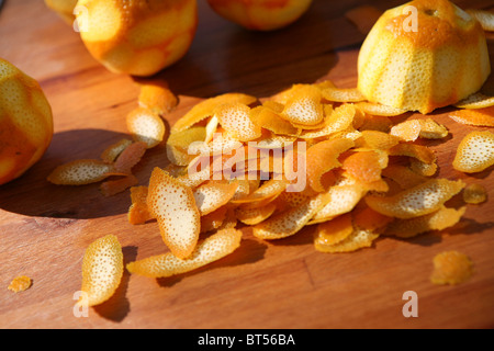 Tas d'écorce d'orange sur une planche à découper en bois, à l'extérieur. Banque D'Images