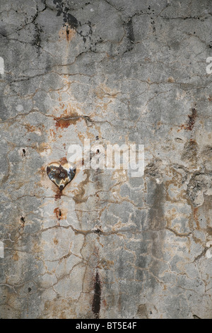 Un vieux coeur ornement sur un mur de pierre dans un cimetière français. Banque D'Images