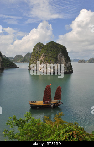Junk avec voile rouge dans la baie d'Halong, Vietnam Banque D'Images