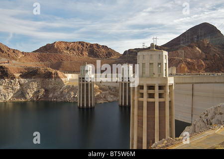 Une vue de trois des quatre tours d'admission au service du barrage Hoover, avec le paysage montagneux en arrière-plan Banque D'Images