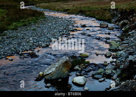 Soir du soleil se reflétant dans les eaux d'Gatesgarthdale Beck près de Buttermere, Lake District, Cumbria Banque D'Images