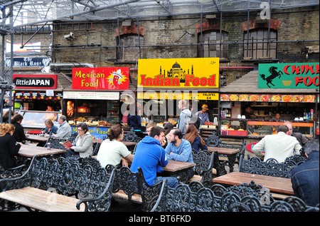 Les personnes mangeant des aliments ethniques au marché de Camden, Camden Town, London UK Banque D'Images
