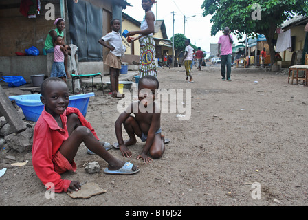 Enfants jouant sur un terrain boueux dans la rue Treicheville, Abidjan, Côte d'Ivoire, Afrique de l'Ouest Banque D'Images