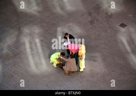 Les représentants des ouvriers et l'inspection d'un trou dans la chaussée, Valencia, Espagne Banque D'Images