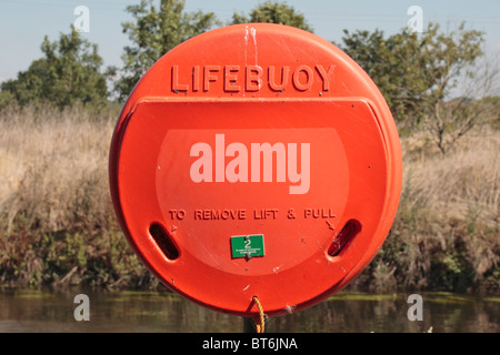 Une bouée orange vif au bord d'une rivière dans le Staffordshire, au Royaume-Uni. Banque D'Images