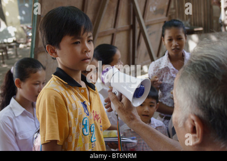 Un garçon de 9 ans est d'apprendre à parler dans un mégaphone à une assemblée de l'école à l'École d'Angkor à Kampong Cham, au Cambodge. Banque D'Images