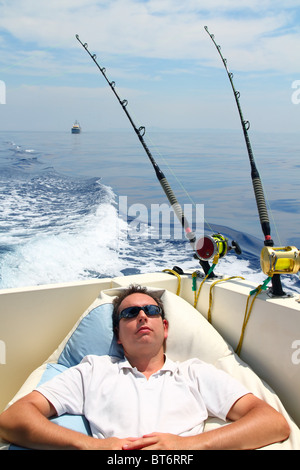 L'homme marin bateau de pêche se reposant dans la mer bleu vacances d'été Banque D'Images