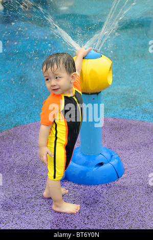 15 mois Garçon jouant dans l'eau parc au Singapore Science Centre. Banque D'Images