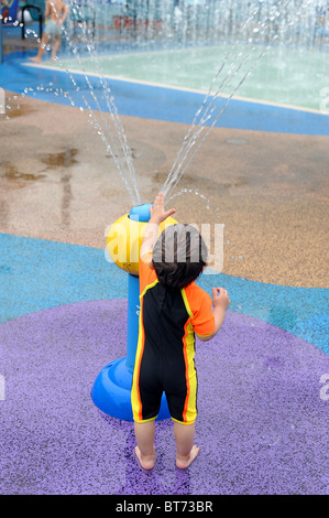 15 mois Garçon jouant dans l'eau parc au Singapore Science Centre. Banque D'Images