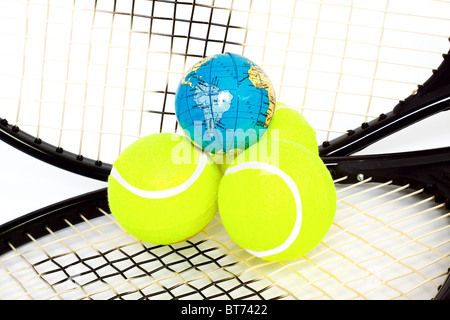 Balles et raquettes de tennis sur globe isolé sur fond blanc Banque D'Images