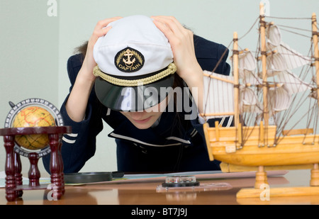 La femme triste dans un uniforme de la mer à la table Banque D'Images
