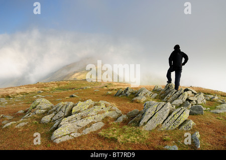 Walker sur Grand Rigg en regardant vers le sommet du nuage enveloppé dans le lac Fairfield English du district Banque D'Images