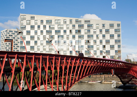 L'architecture moderne : pont en acier rouge à Amsterdam, Eastern Docklands Sfinx building en arrière-plan, par Frits van Dongen Banque D'Images