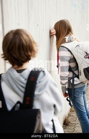 Garçon et fille soutenant dans la cour de l'école Banque D'Images