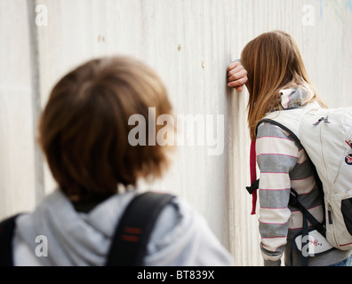 Garçon et fille soutenant dans la cour de l'école Banque D'Images