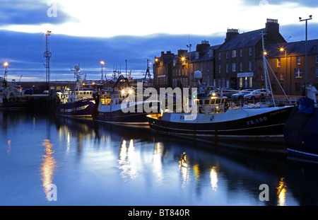 Le village de pêcheurs d'Aberlour dans le nord est de l'Ecosse, Royaume-Uni, vu éclairée le soir avec les bateaux de pêche amarrés jusqu Banque D'Images