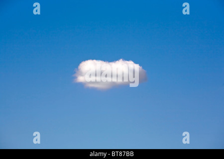 Un seul nuage flottant dans un ciel bleu. Banque D'Images