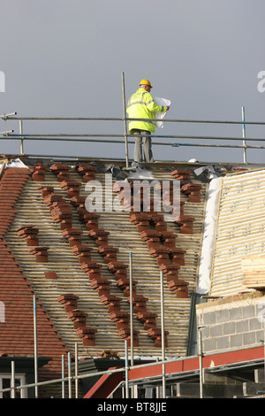 Les constructeurs de construire de nouvelles maisons sur un champ vert à Bolnore site Village. Photo par James Boardman. Banque D'Images