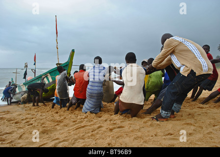 Les pêcheurs tirer dans un bateau sur le chaque à Sassandra, Côte d'Ivoire, Afrique de l'Ouest Banque D'Images