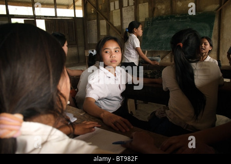 Les jeunes âgés de l'école élémentaire les élèves, garçons et filles, prenez une pause de ses études à l'école primaire de Parti communiste du Laos. Banque D'Images