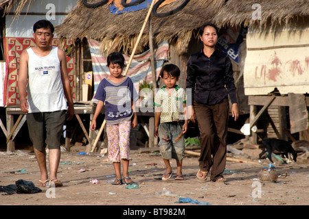 Un homme et sa famille qui vivent dans la pauvreté sont la marche dans un taudis au Cambodge. Banque D'Images