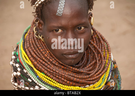 Les Nyangatom (Bumi) femme avec des tas de billes dans son village, la vallée de la rivière Omo, en Ethiopie Banque D'Images