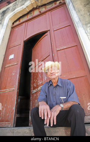 TRINIDAD : CUBAN MAN SITTING IN DOORWAY Banque D'Images