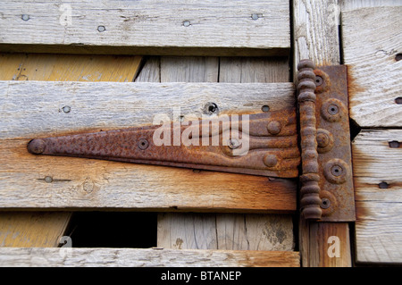 L'Islande, péninsule de Reykjanes, Grindavik. Charnière rouillée sur la vieille porte de grange en bois. Banque D'Images