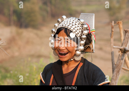 A smiling femme Akha avec dents noircie portant une coiffe d'argent traditionnels Banque D'Images