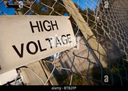 Signe de tension élevée est élevé sur un fil (cyclone) fence Banque D'Images