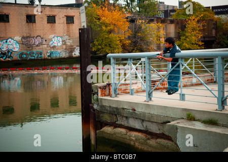 Un garçon à l'usine de poissons en béton le long de la Bronx River dans le quartier de New York dans le Bronx Banque D'Images