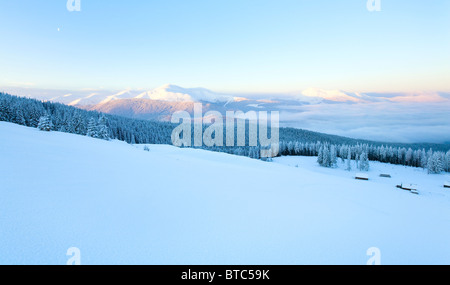 Lever du soleil et l'hiver paysage de montagne avec des maisons en groupe sur la pente. Vue depuis le mont Kukol. (Carpates, Ukraine) Banque D'Images