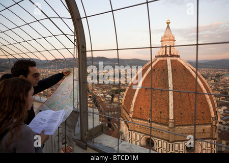 La coupole de Brunelleschi et map-holding vu de touristes sur le clocher de Giotto (campanile) à Florence. Banque D'Images