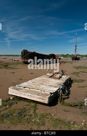 Vieux bateau ponton, avec en arrière-plan des barges sur la rivière Orwell, broche Mill, dans le Suffolk. Banque D'Images