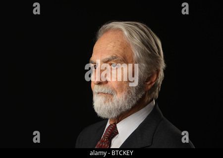 Portrait de phoque barbu et aux cheveux gris senior businessman en costume et cravate, studio shot, fond noir, le 16 octobre, 2010 Banque D'Images