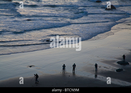 Les photographes qui se profile sur Bandon plage au coucher du soleil avec seastacks sur la côte de l'océan Pacifique de l'Oregon Bandon Banque D'Images