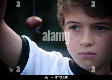 Un garçon est titulaire d'un conker sur une chaîne de caractères pour le jeu conker Banque D'Images
