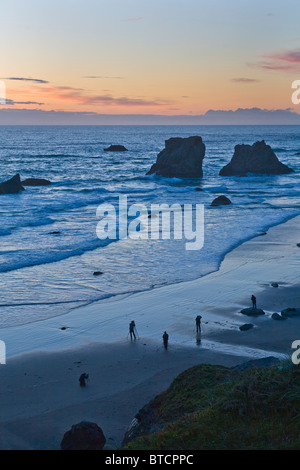 Les photographes qui se profile sur Bandon plage au coucher du soleil avec seastacks sur la côte de l'océan Pacifique de l'Oregon Bandon Banque D'Images